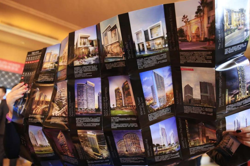 Visitors look at a brochure during an event in Beijing showcasing luxury properties from more than 35 countries, including Australia, Canada, Spain, Uruguay, and the United States. Photo: EPA