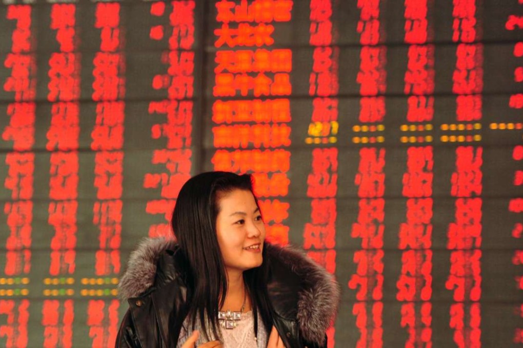 An investor in front of a screen showing stock market movements at a securities firm in Fuyang, east China's Anhui province. Photo: AFP