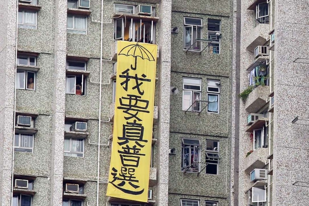A banner calling for genuine universal suffrage is draped outside a residential building next to a home for the elderly in Tseung Kwan O that Zhang Dejiang visited on Thursday. Photo: Nora Tam