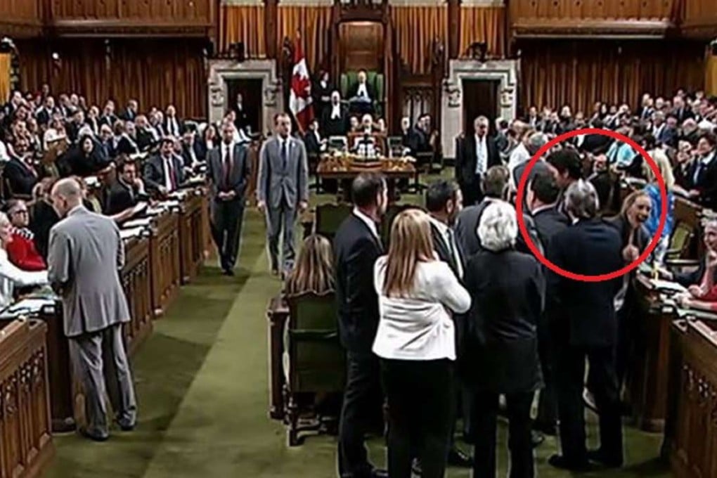 MP Ruth Ellen Brosseau, a member of the opposition NDP, is seen recoiling as Prime Minister Justin Trudeau hustles past in this image from the Canadian parliamentary video feed. Photo: CBC