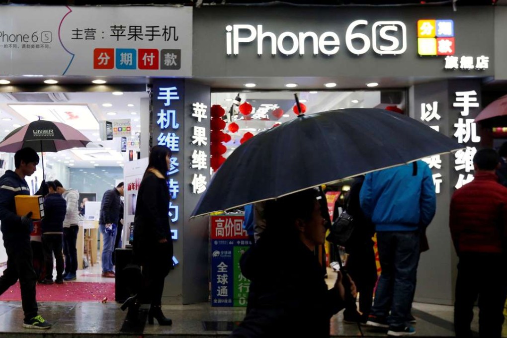 People walk past stores promoting the Apple iPhone 6S in the southern city of Shenzhen on January 26, 2016. Photo: Reuters