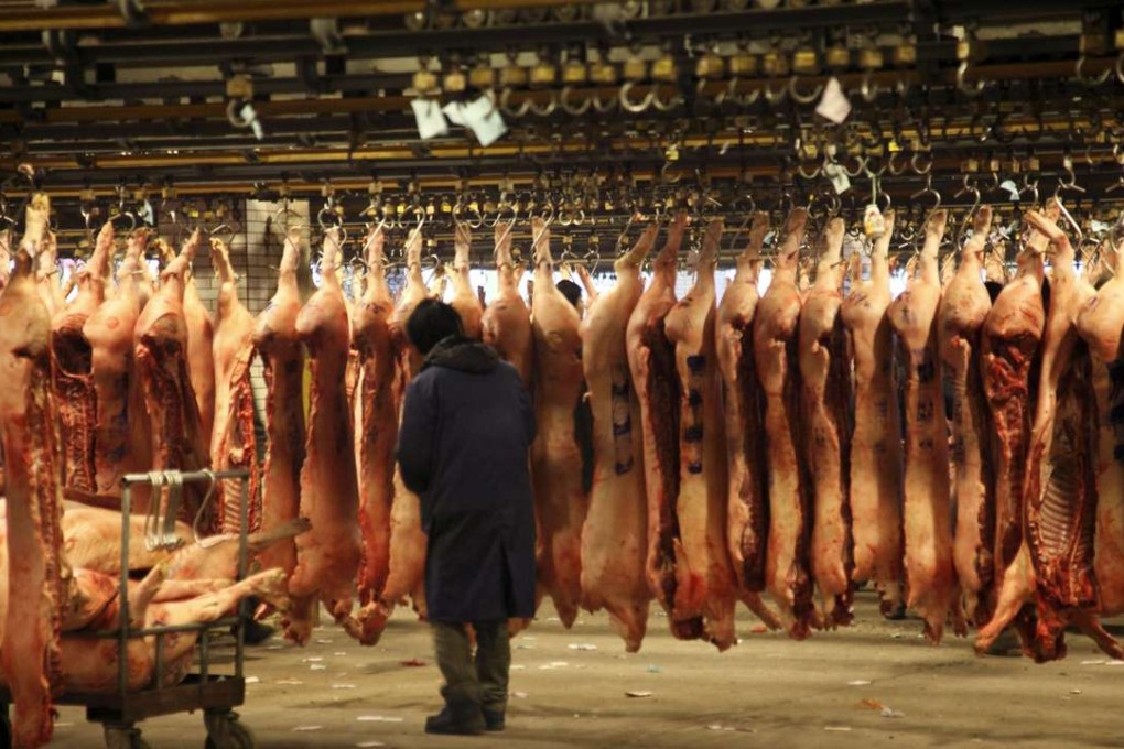 Workers unload pig carcasses for sale at a wholesale market in Shanghai. Photo EPA, Qilai Shen