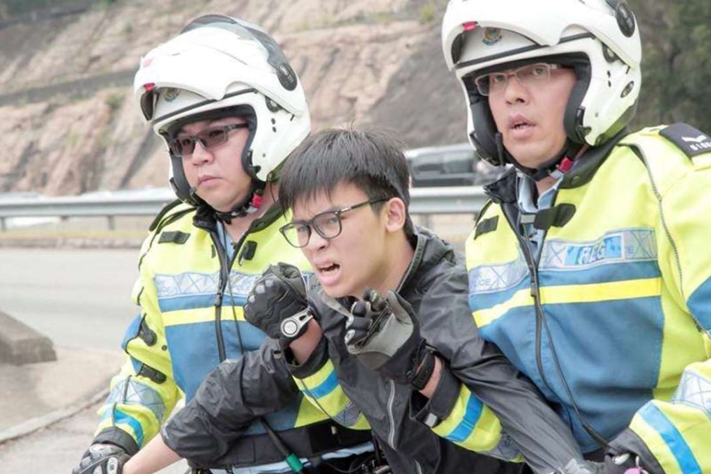 Oscar Lai was taken away from the highway by police officers. Photo: SCMP Pictures