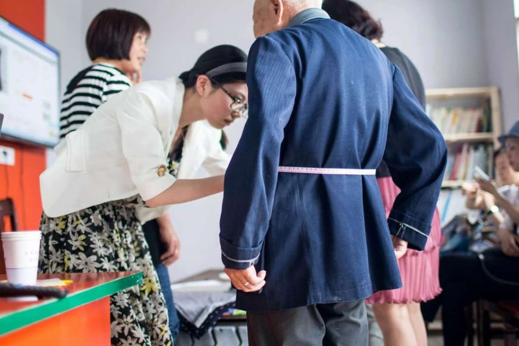 A “rural partner” measures an old man’s waist in Louyan village of Fenghua, Zhejiang province, before buying him a sweater online. Photo: SCMP Pictures (Handout)