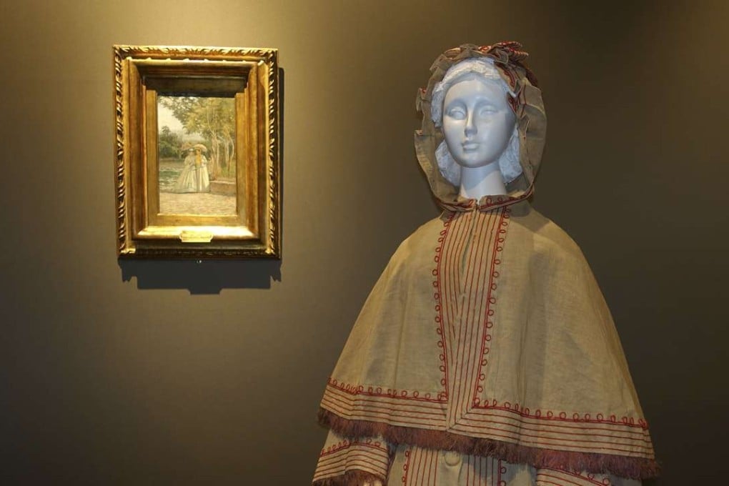 An 1865 Italian-made linen garden dress with hooded cape, shown alongside a 19th Century painting from the Uffizi Gallery's Galleria d’Arte Moderna collection depicting a similar style for a collateral show at Pitti Palace in Florence, Italy. Photo: AP