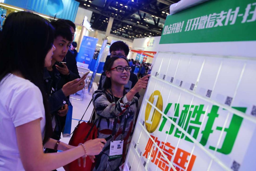 Visitors use the WeChat payment system for gifts at the 2016 Global Mobile Internet Conference in Beijing. Photo: EPA