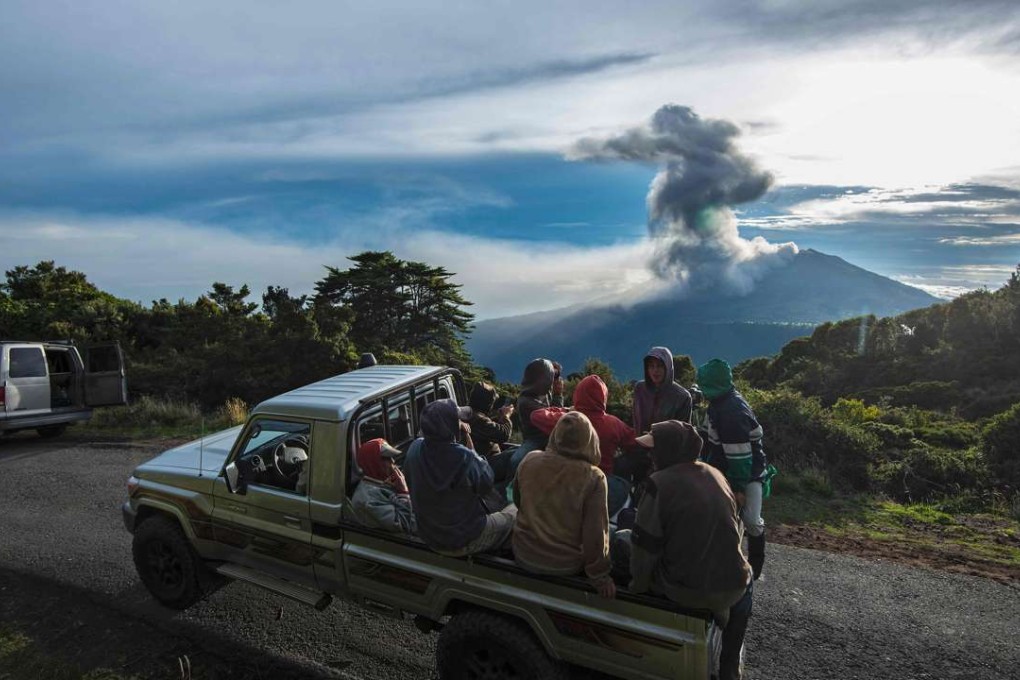 Farmers are transported on the back of a truck as the Turrialba volcano erupts in the background on May 20, 2016, in Cartago, Costa Rica. The Turrialba volcano started erupting columns of smoke and ash that the wind extended towards the Costa Rican capital, in what according to experts is the strongest eruption in the past six years. Photo: AFP