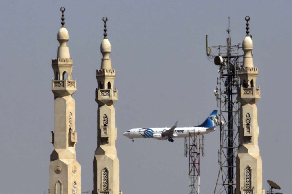An EgyptAir plane flies past minarets of a mosque as it approaches Cairo International Airport, in Cairo. Photo: AP