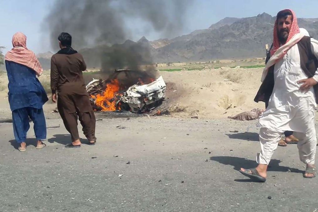 Pakistani local residents gather around a destroyed vehicle that was hit by a drone strike in which Afghan Taliban leader Mullah Akhtar Mansour was believed to be travelling in. Photo: AFP