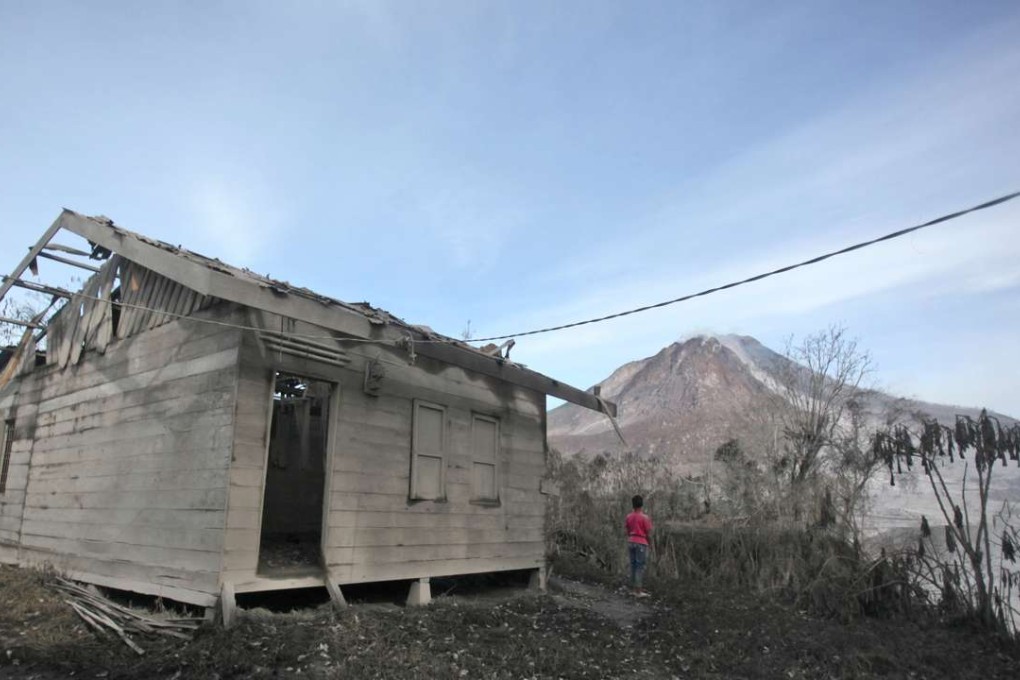 A young boy watches Mount Sinabung in Gamber village, North Sumatra, Indonesia. Photo: AP