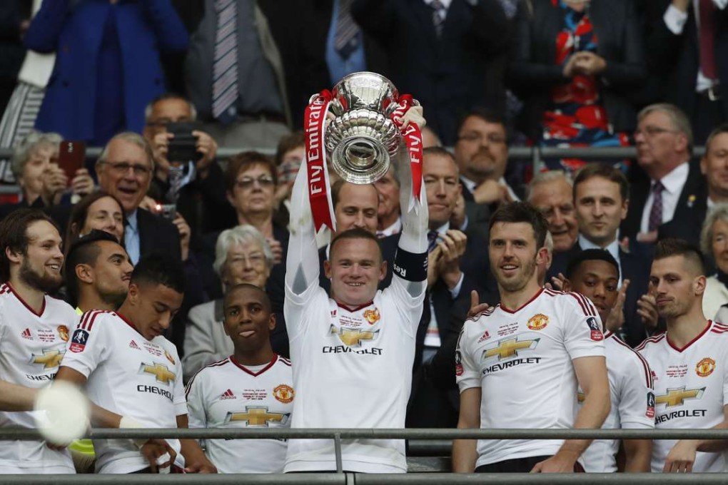 Manchester United's Wayne Rooney celebrates with the trophy after winning the FA Cup with teammates Photo: Reuters