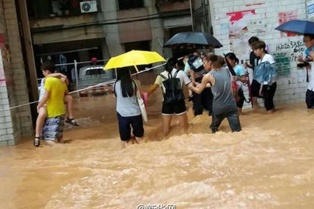 Zhou Tufang (right, in grey shirt) pictured leading the children to safety in Maoming. Photo: 163.com