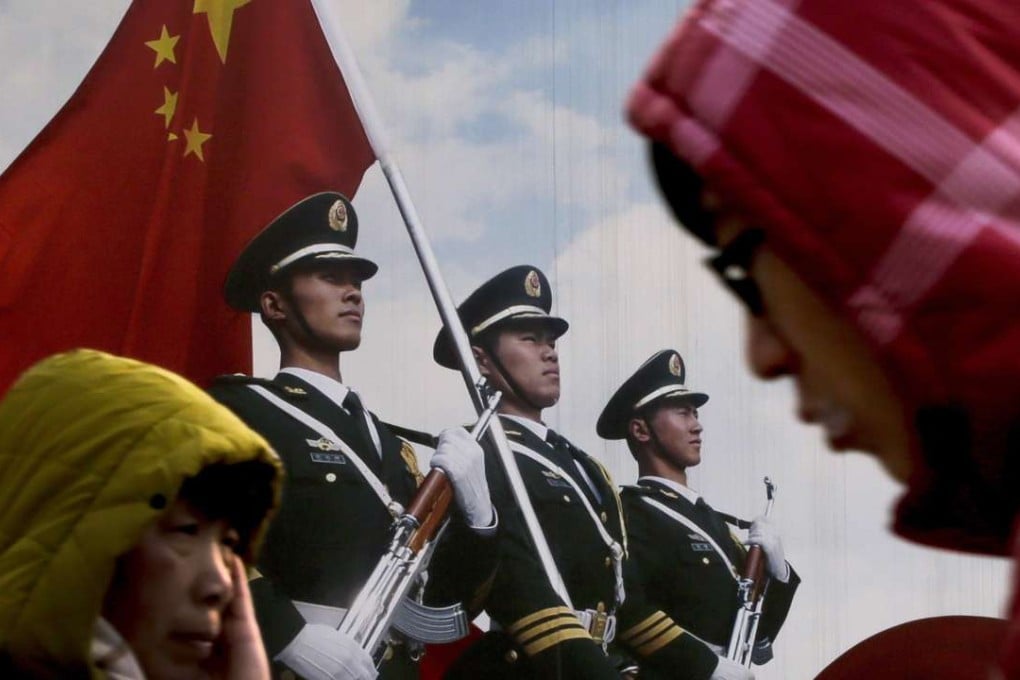 People walk past a poster of Chinese People's Liberation Army soldiers in Beijing. Photo: AP