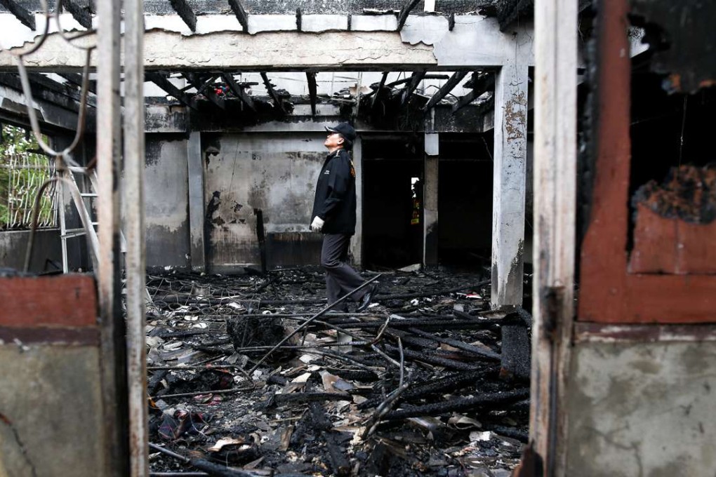 A police officer inspects the gutted building. Photo: Reuters
