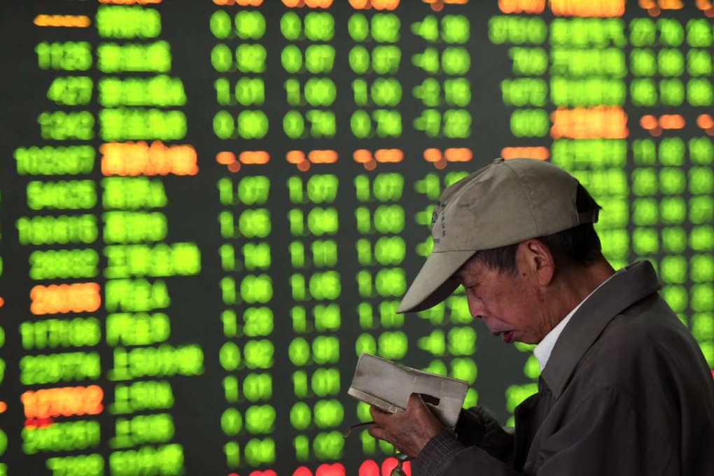 A Chinese investor checks his notes while monitoring stock prices at a brokerage house in Hangzhou in eastern China's Zhejiang province. Photo: AP