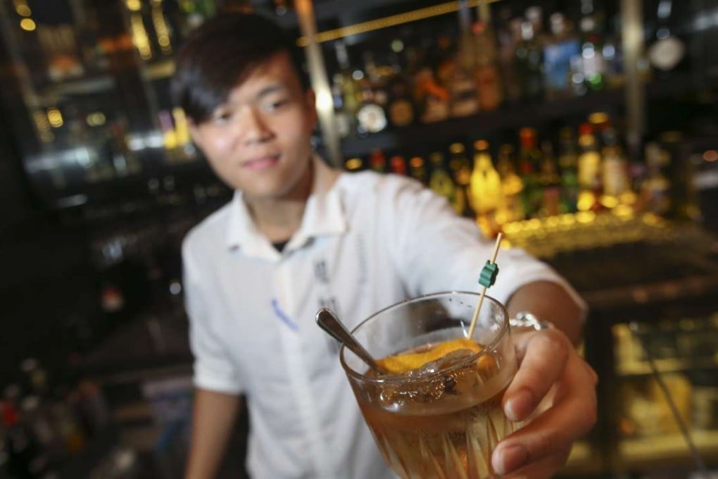 Barman Peter Sit offers a New Fashioned drink at La Bo La in Wan Chai. Photos: David Wong Wong