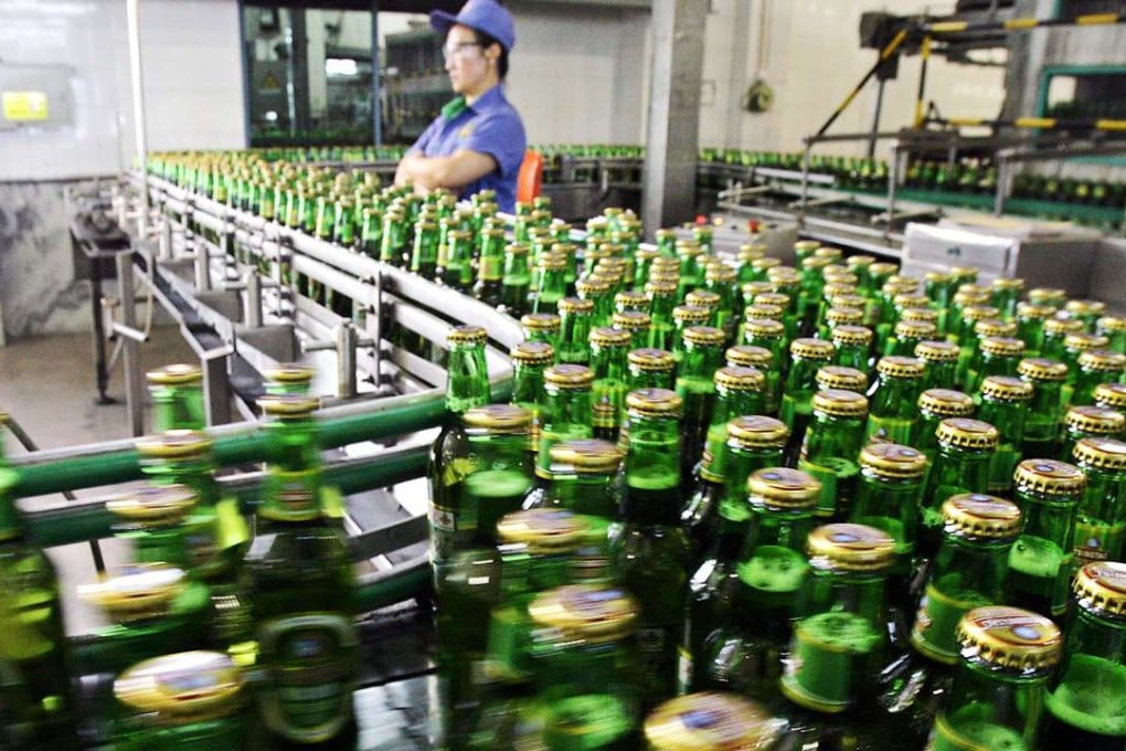A worker inspects the bottles of Tsingtao beer rolling out from one of the four breweries in the eastern Chinese port city of Qingdao. Residue at a site in China showed Chinese were brewing beer 5,000 years ago. Photo: AFP