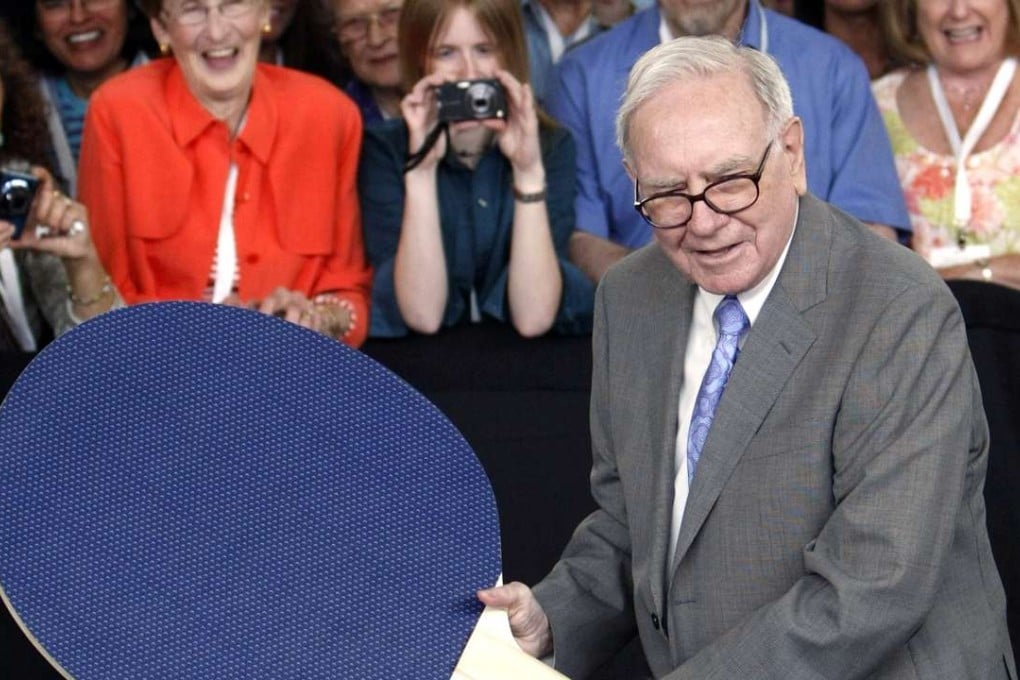 Berkshire Hathaway chairman Warren Buffett plays table tennis with world champion Ariel Hsing using a giant paddle. Photo; Reuters, Rick Wilking