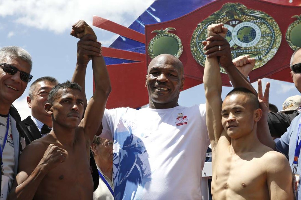 Former heavyweight champion Mike Tyson poses with boxers, Xiong Chaozhong of China and Jose Jimenez of Colombia during the weigh-in for the IBF World Championships in Beijing. Photo: AP