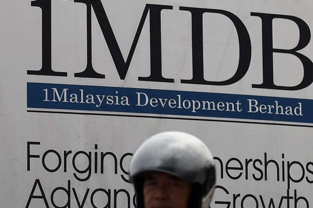 A motorist riding past a hoarding at the construction site of the 1 Malaysia Development Berhad (1MDB) flagship Tun Razak Exchange in Kuala Lumpur. Photo: AFP