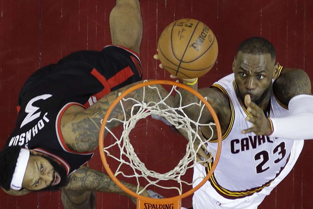 LeBron James shoots against Toronto Raptors' James Johnson. Photo: AP