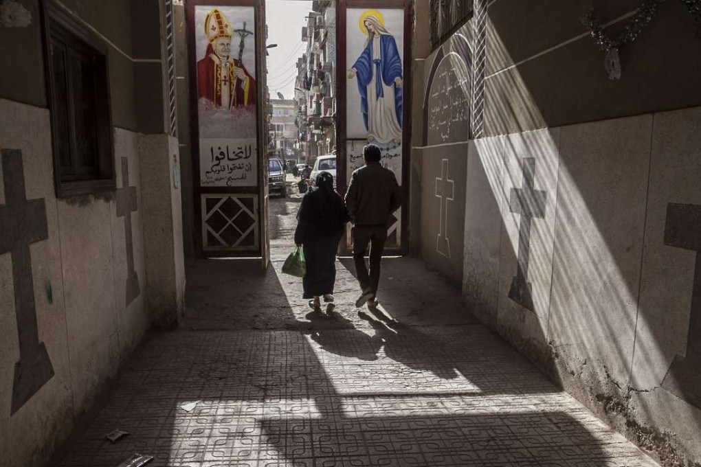 Coptic Christians walk outside St Markos Church in Minya province, south of Cairo. A Muslim mob ransacked and torched seven Christian homes in a province, after rumors spread that a Christian man had an affair with a Muslim woman. Photo: AP