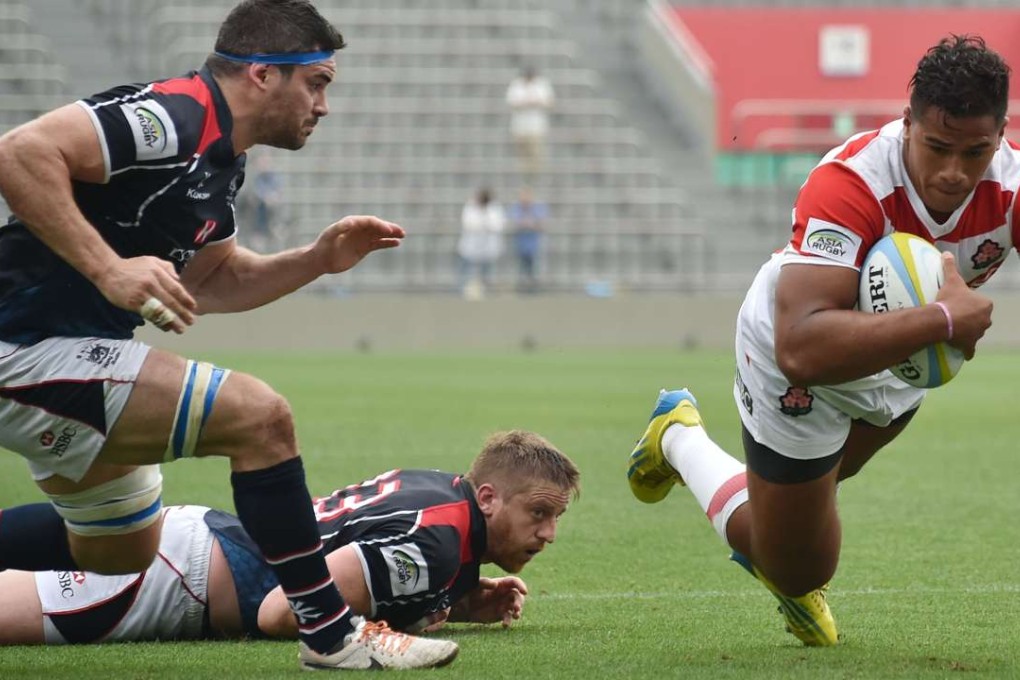 Hong Kong flanker Matthew Lamming can’t prevent Japan winger Ataata Moeakiola diving in for a try in their Asia Rugby Championship match in Tokyo. Photos: AFP