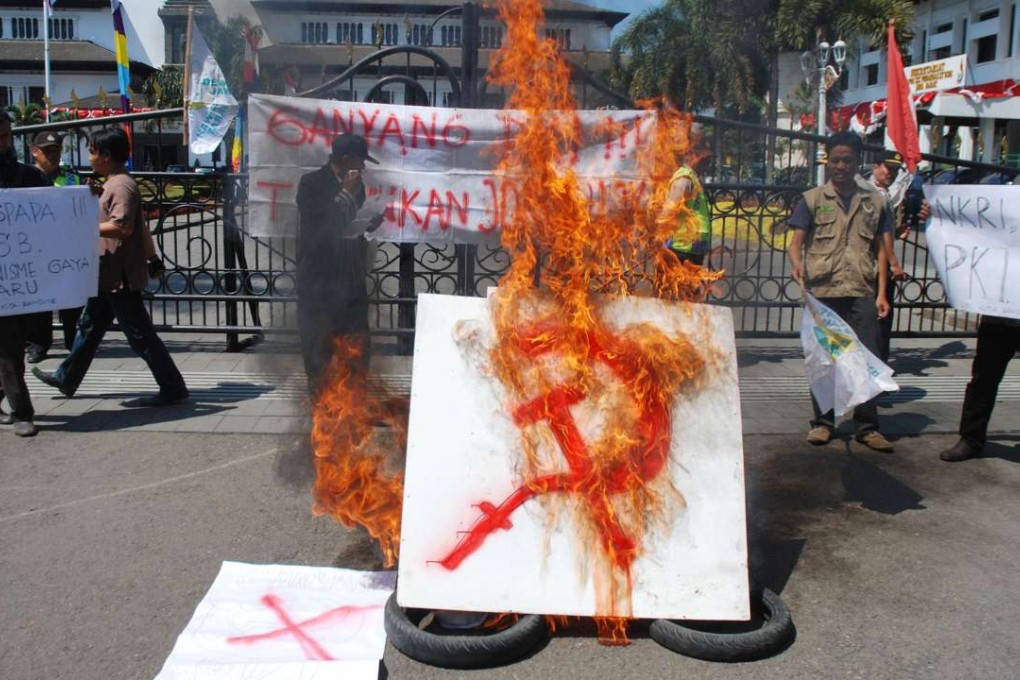An anti-communism group burns a communist symbol during a rally in Bandung, West Java province. Police and the military have in recent weeks rounded up people for allegedly spreading communism – which remains outlawed in Indonesia – through logos on T-shirts. Photo: AFP