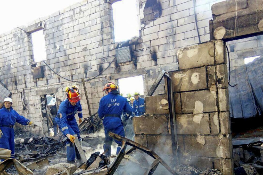 Rescuers inspect the debris of a residential house after a fire broke out, in the village of Litochky, northeast of Kiev, Ukraine, May 29, 2016. Photo: Reuters