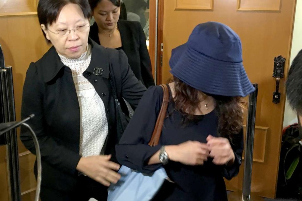 One of the 12 nurses (in blue hat) leaving the Nursing Council hearing after being cleared of all charges. She refused to comment on the incident. Photo: Emily Tsang