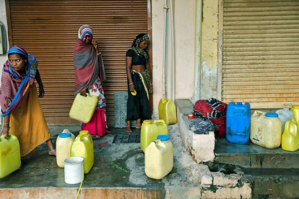 Women fill water containers from an underground tank on the outskirts of Ahmedabad, India. Improved access to sanitation, electricity, clean water supplies and transport reduces “time poverty” for women and girls, according to a study by the Asian Development Bank. Photo: Reuters