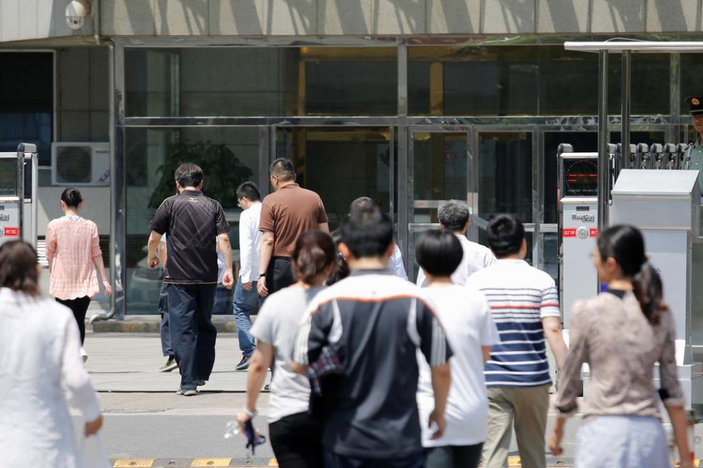 A security guard stands at the entrance of the building where the China's Food and Drug Administration main office is located as people come back from lunch break in Beijing on May 17, 2016. Photo: Reuters