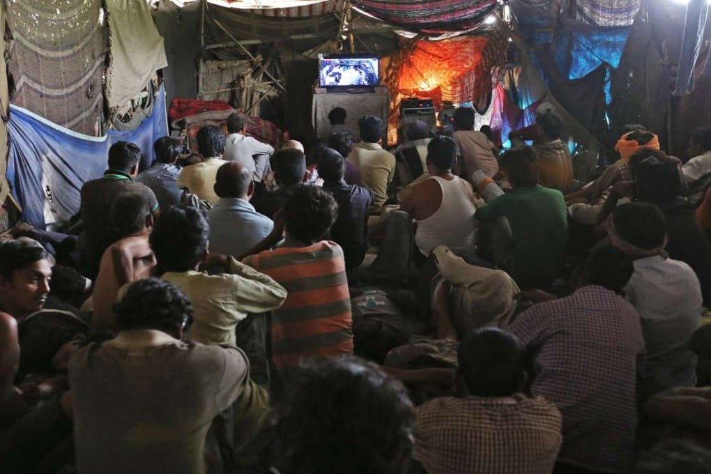 People watch a film in the makeshift cinema under a bridge in the old quarter of Delhi. Photos: Reuters