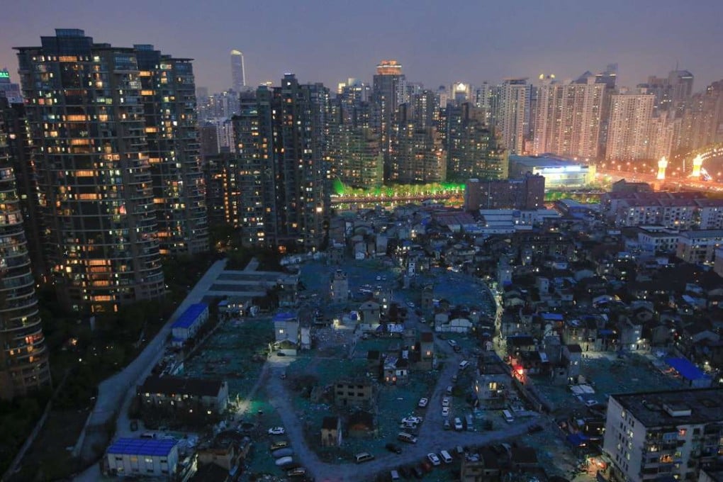 A night view of the old houses surrounded by new apartment buildings at Guangfuli neighbourhood in Shanghai, China. Photo: Reuters, Aly Song