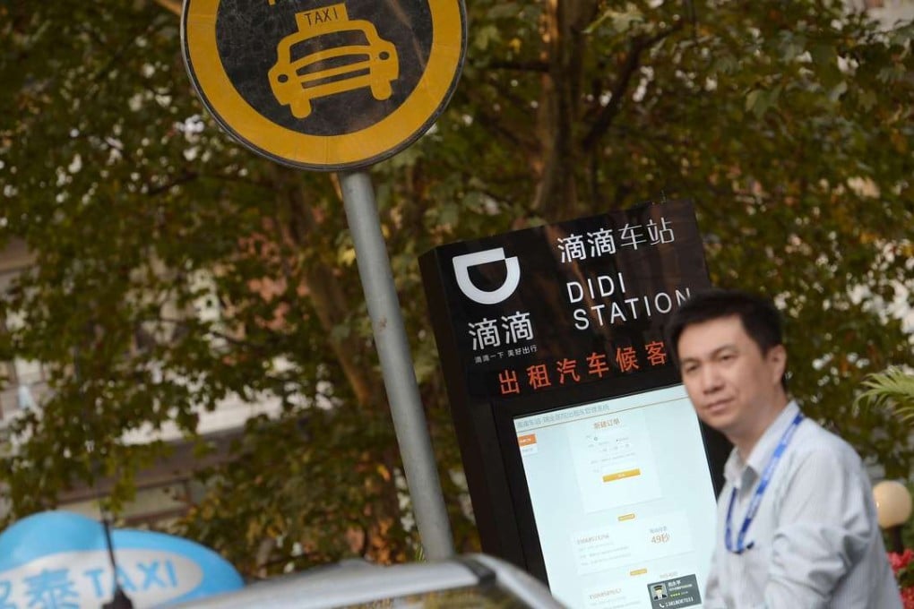 A taxi driver waits at a newly-installed Didi Station, a road-side stop for taxis booked by the Chinese car-hailing app Didi Kuaidi, which has since changed its name to Didi Chuxing, in Shanghai. Didi Chuxing announced on May 13, 2016, that Apple has invested $1 billion in the company and will become a strategic investor alongside Chinese e-commerce giant Alibaba Group and Tencent Holdings. Photo: Chinatopix via AP