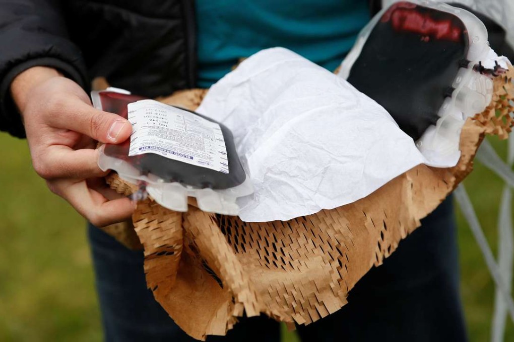 A Zipline employee displays a package of fake blood airdropped by one of its drones during a flight demonstration in the San Francisco Bay Area, California. This summer, the company will start delivering blood to hospitals and health centres in Rwanda. Photo: Reuters