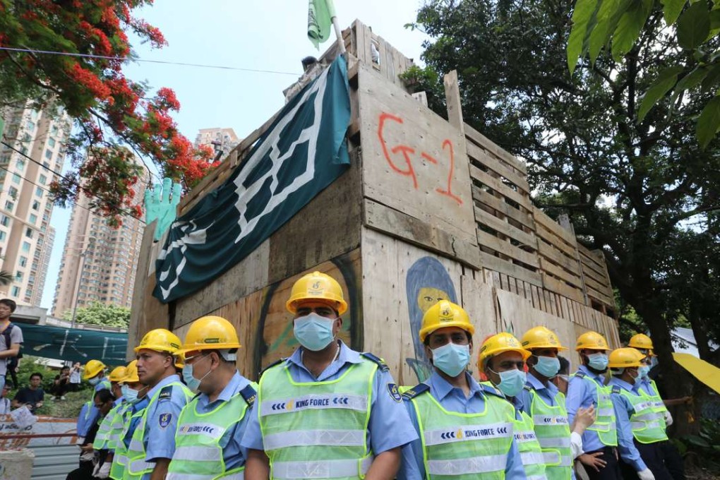 Security guards surround a wooden structure ascended by opponents of a development plan in the New Territories. Photo: Felix Wong