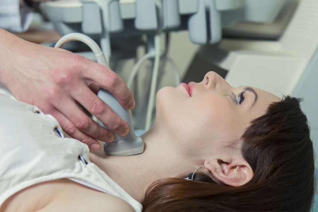 A woman undergoes an ultrasound of her thyroid.