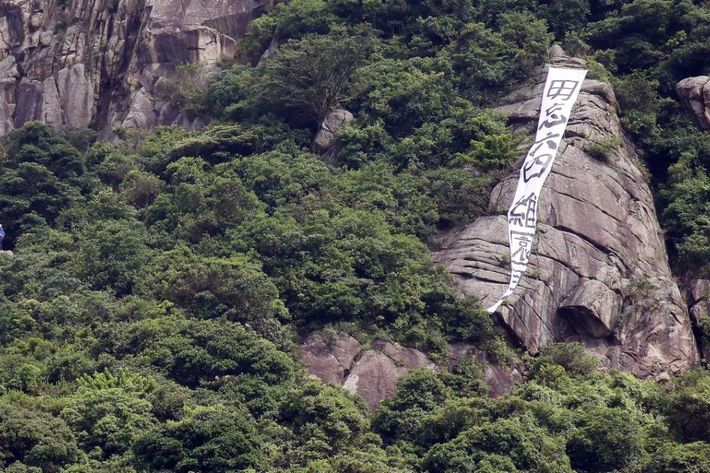 At 9.10am, firefighters (left) were seen at the scene ready to remove the banner. Photo: Felix Wong