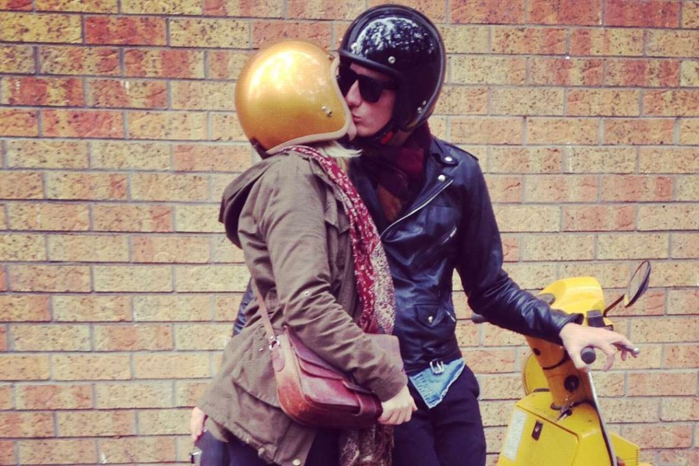 A couple smooching next to a Vespa PX-200 scooter in Hong Kong.