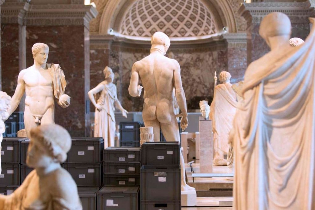 Boxes containing valuable artworks from the Louvre reserves stored among status in one of the museum's exhibition room after they were evacuated from the basement. Photo: AFP