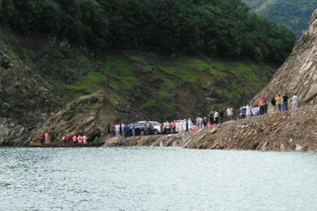 People gather by the lake where the boat sank. The vessel had 11 passengers on board. Photo: SMP Pictures