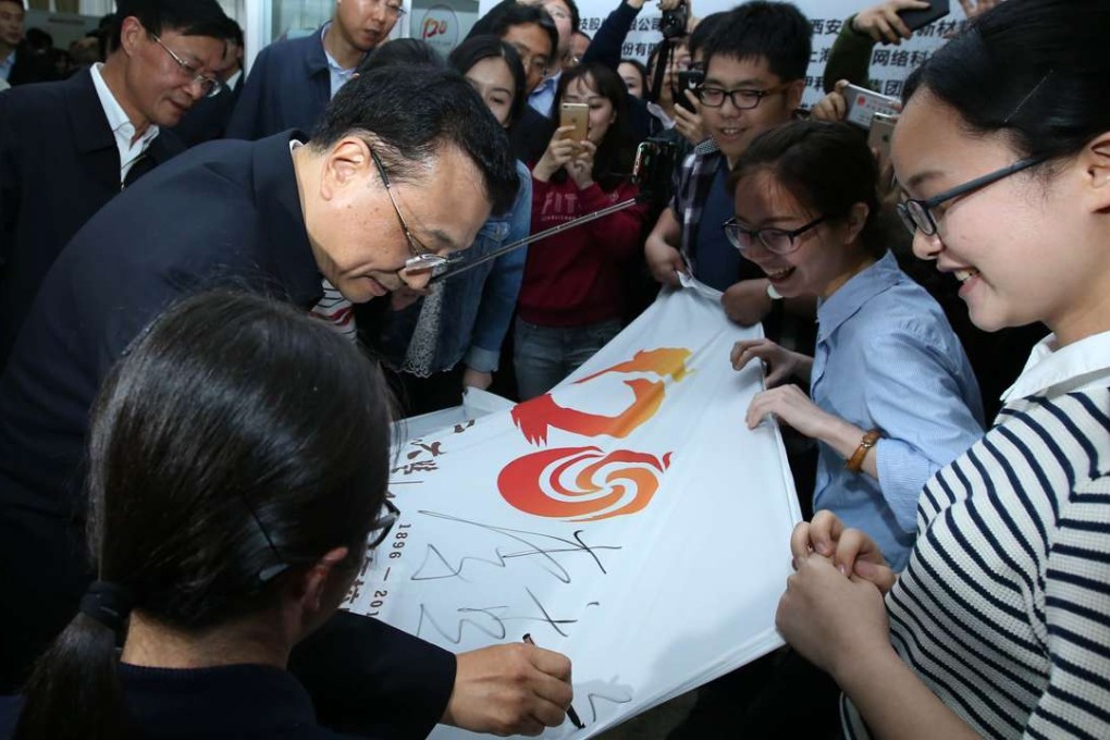 Premier Li Keqiang signs a poster during a visit to Sichuan University in Chengdu in April. Photo: Xinhua