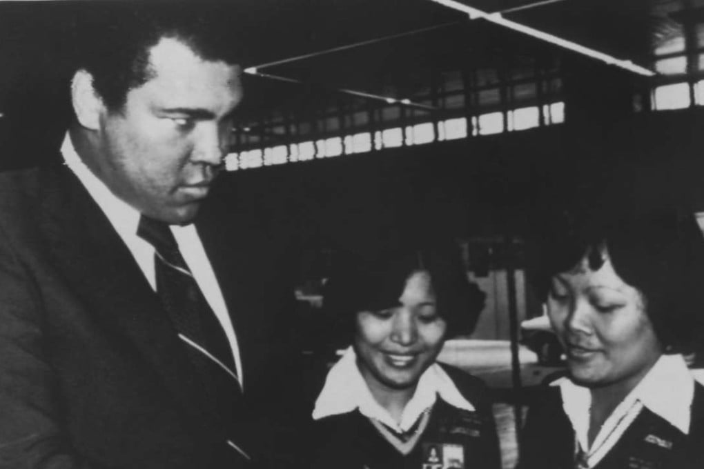 Muhammad Ali playfully glares at two women security guards as they check his travel documents at Hong Kong’s Kai Tak airport in December 1979 while on his way to mainland China. Photo: AP