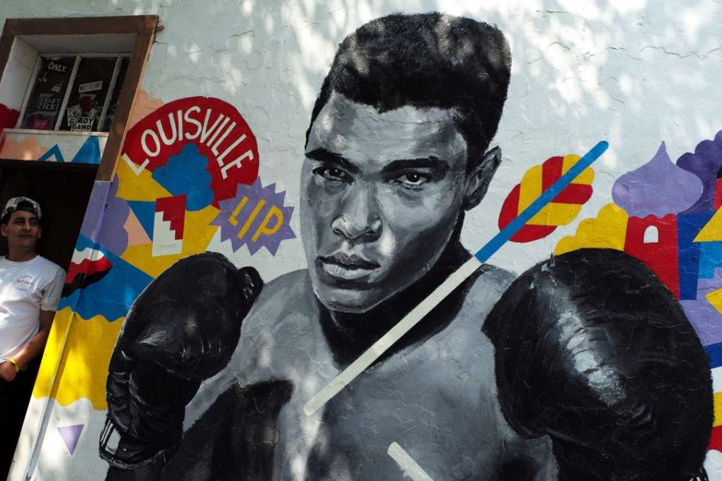 A man stands next to a mural of boxer Muhammad Ali in New York on Saturday. Photo: AFP