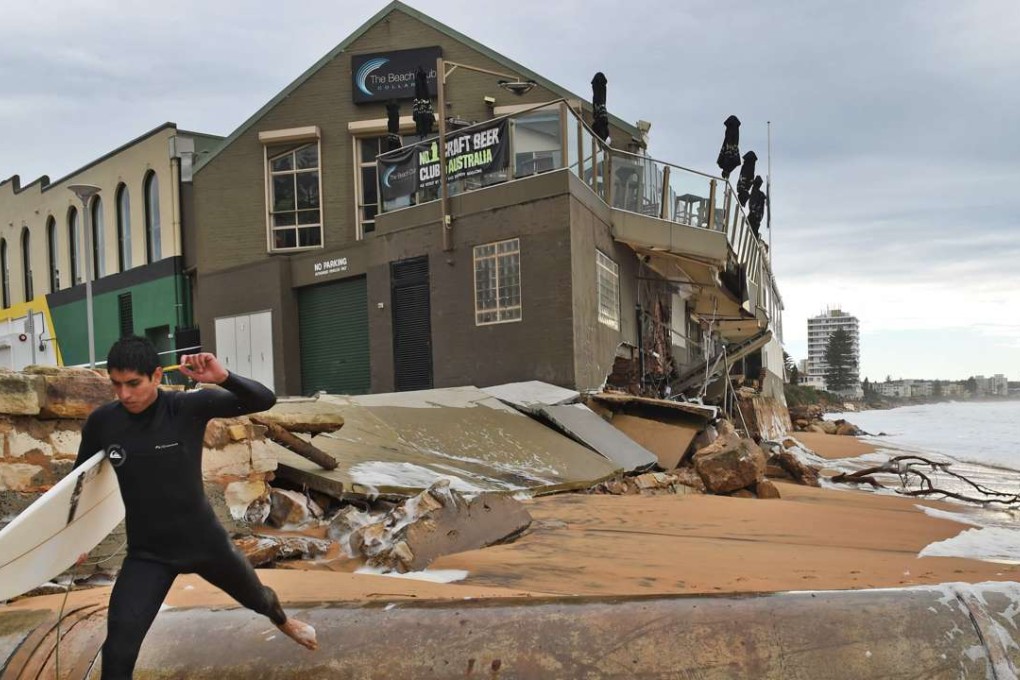 A local resident looks at the damage caused by a severe storm at Collaroy on Sydney's northern beaches. Photo: AFP