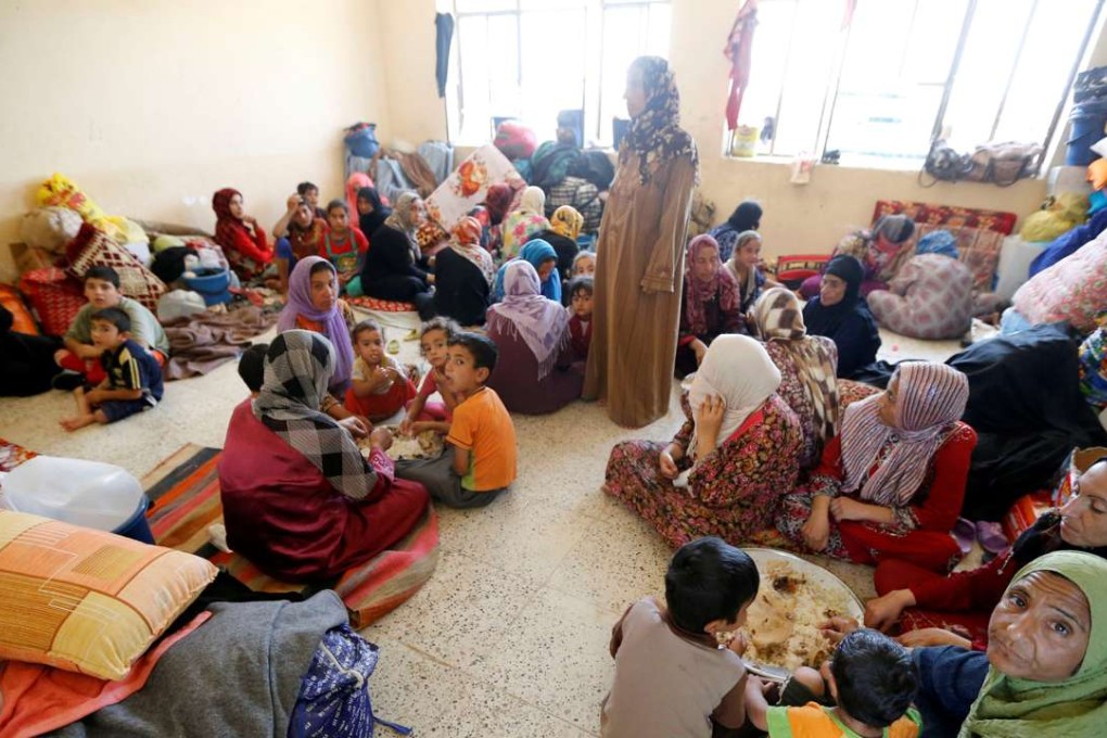 Civilians who fled their homes from the clashes on the outskirts of Fallujah gather in a school on the outskirt of Garma, Iraq. Photo: Reuters