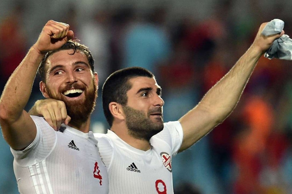 Georgia's defender Guram Kashia (L) and midfielder Jano Ananidze celebrate their 1-0 victory. Photo: AFP