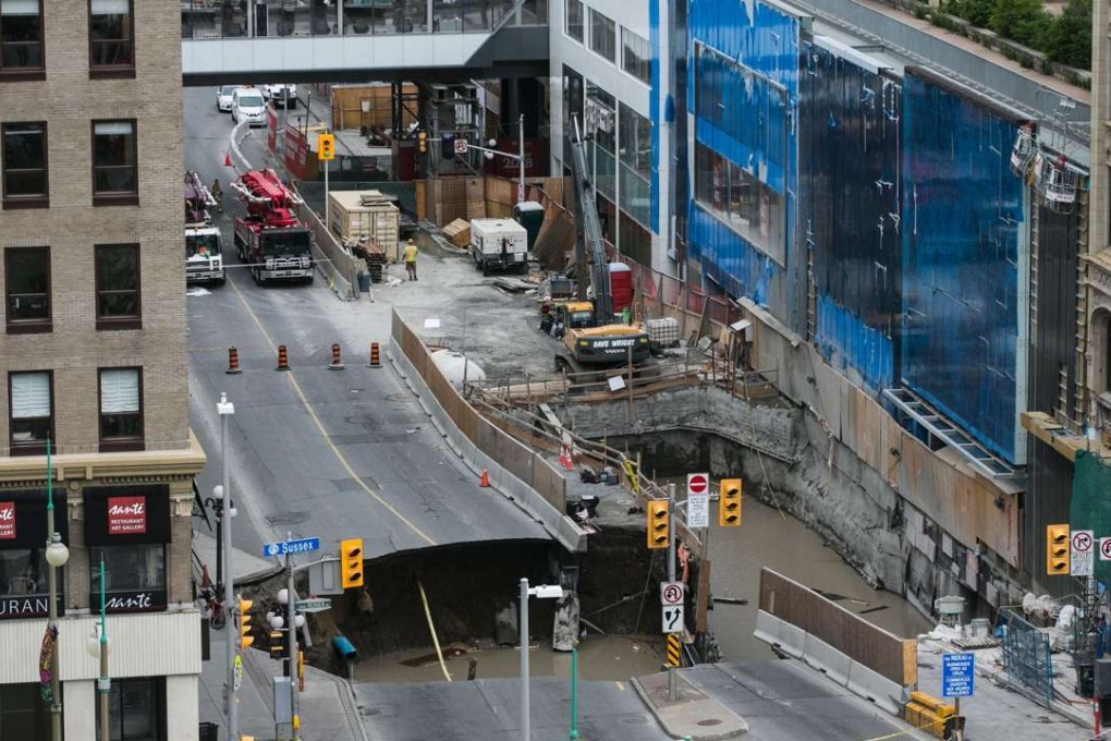 A large portion of Rideau Street in downtown Ottawa is seen caved in, causing a massive sinkhole on Wednesday. Photo: AFP