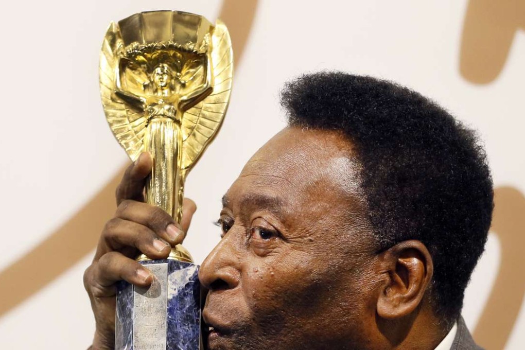 Pele with his copy of the Jules Rimet Trophy, which has been sold at auction. Photo: AP